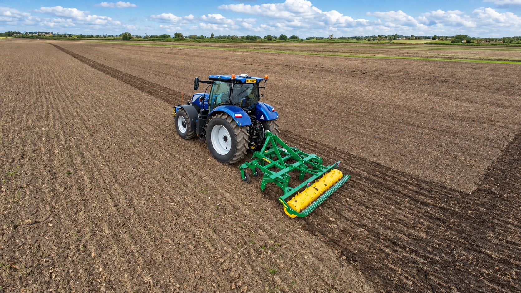 Cousins cultivation equipment working the soil behind a tractor in a British field